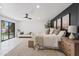 Airy main bedroom featuring bright white walls, neutral furniture, a ceiling fan, and a sliding glass door at 7409 E Pleasant Run, Scottsdale, AZ 85258