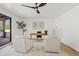 Bright home office features modern ceiling fan, neutral decor, and light wood desk space with two armchairs at 7409 E Pleasant Run, Scottsdale, AZ 85258