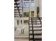 Modern staircase featuring black wooden steps, unique lighting fixture, and white rock landscape with cacti at 7409 E Pleasant Run, Scottsdale, AZ 85258