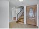 Bright foyer featuring tile flooring, a wooden staircase, and a decorative front door at 7632 E Bonita Dr, Scottsdale, AZ 85250