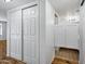 Hallway with closet doors leading to a bathroom, featuring laminate wood flooring and fresh white walls at 7632 E Bonita Dr, Scottsdale, AZ 85250