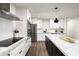 A closer view of the renovated kitchen with white cabinets, stainless steel appliances, herringbone backsplash and center island at 8341 E Hubbell St, Scottsdale, AZ 85257