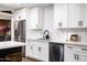 Bright kitchen featuring modern appliances, white cabinets, quartz countertops, tiled backsplash and gold barstool seating at 8341 E Hubbell St, Scottsdale, AZ 85257