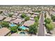 An aerial view showcasing houses with backyard pools and nearby roads in a residential neighborhood at 8664 W Yukon Dr, Peoria, AZ 85382