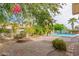 Relaxing backyard oasis with a pool, mature trees, and a paver patio at 8664 W Yukon Dr, Peoria, AZ 85382