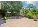 Private backyard featuring desert landscaping, a brick patio, and mature trees at 8664 W Yukon Dr, Peoria, AZ 85382