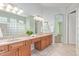 Bright bathroom featuring double sink vanity, tile floors, and glass block shower at 8664 W Yukon Dr, Peoria, AZ 85382
