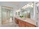 Bathroom featuring a dual sink vanity and glass block shower at 8664 W Yukon Dr, Peoria, AZ 85382
