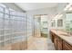 A luxurious bathroom featuring a glass block shower and dual sink vanity at 8664 W Yukon Dr, Peoria, AZ 85382
