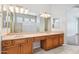 Bright bathroom featuring a double sink vanity, large mirror, and glass block shower at 8664 W Yukon Dr, Peoria, AZ 85382