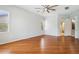 Bright bedroom featuring hardwood floors, neutral walls, ceiling fan and access to an adjacent room at 8664 W Yukon Dr, Peoria, AZ 85382
