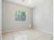 Clean, simple bedroom with neutral walls, tile floors, chandelier, and large window at 8664 W Yukon Dr, Peoria, AZ 85382