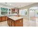 Well-lit kitchen features granite countertops, wooden cabinets, and an island with views of the adjacent room at 8664 W Yukon Dr, Peoria, AZ 85382