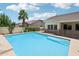 Backyard pool featuring blue water, safety fence and a palm tree; great for outdoor enjoyment at 8664 W Yukon Dr, Peoria, AZ 85382