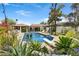 Lush backyard with a sparkling pool, diving board, pergola covered patio, and vibrant greenery creates a private paradise at 10157 E San Salvador Dr, Scottsdale, AZ 85258