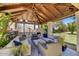Inviting covered patio featuring an outdoor fireplace, comfortable seating, and a stylish blue patterned rug at 10157 E San Salvador Dr, Scottsdale, AZ 85258