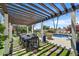 Charming outdoor dining area under a pergola, overlooking a beautiful pool, perfect for entertaining guests at 10157 E San Salvador Dr, Scottsdale, AZ 85258