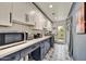 Well-lit laundry room with stylish tile floors, modern cabinets, and stainless steel appliances at 10157 E San Salvador Dr, Scottsdale, AZ 85258