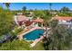 An aerial view of a gorgeous pool area with an outdoor kitchen, lounge chairs, and lush landscaping at 10157 E San Salvador Dr, Scottsdale, AZ 85258