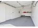 Clean, well-lit garage with epoxy flooring, overhead storage, and a side entry door at 11260 N 92Nd St # 2054, Scottsdale, AZ 85260