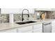 A black kitchen sink and counter with modern faucet, tile backsplash and stainless steel dishwasher at 11260 N 92Nd St # 2054, Scottsdale, AZ 85260