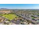 Aerial view of a beautiful home near a green field and park in a well-maintained community with mountain views at 1443 N Poppy St, Casa Grande, AZ 85122
