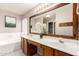 Bathroom with a double sink vanity, large mirror, and a soaking tub at 1443 N Poppy St, Casa Grande, AZ 85122