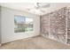 Cozy bedroom featuring a brick accent wall and a window offering natural light at 1443 N Poppy St, Casa Grande, AZ 85122