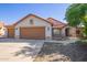 Welcoming single-story home featuring a three-car garage, desert landscaping, and a red tile roof at 1443 N Poppy St, Casa Grande, AZ 85122