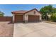 View of the house with a terracotta roof, neutral stucco, and a spacious three-car garage at 1443 N Poppy St, Casa Grande, AZ 85122