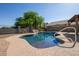 Backyard pool with stone waterfall and lush landscaping, offering a private and tranquil retreat at 1443 N Poppy St, Casa Grande, AZ 85122