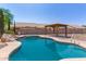 Backyard pool with gazebo and rock waterfall feature offers a relaxing outdoor space at 1443 N Poppy St, Casa Grande, AZ 85122