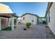 Low-maintenance backyard with gravel, a covered patio, and a brick walkway at 15803 W Almeria Rd, Goodyear, AZ 85395