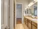 Bathroom featuring double sinks, vanity, and a view to the doorway to the bedroom at 15803 W Almeria Rd, Goodyear, AZ 85395