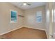Bedroom with neutral carpet, two windows, and a ceiling fan at 15803 W Almeria Rd, Goodyear, AZ 85395