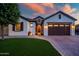Inviting home exterior with a well-manicured lawn, beautiful stonework, and a welcoming entrance at 15803 W Almeria Rd, Goodyear, AZ 85395
