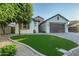 Beautiful home exterior with lush green grass, appealing stonework accents, and mature landscaping at 15803 W Almeria Rd, Goodyear, AZ 85395