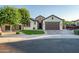 Charming single-story home featuring a manicured front yard and a spacious two-car garage with brown door at 15803 W Almeria Rd, Goodyear, AZ 85395