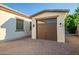 Detached garage featuring carriage doors, brick driveway, and coordinated exterior paint at 15803 W Almeria Rd, Goodyear, AZ 85395