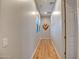Hallway with hardwood floors, white trim and doors, and a decorative wall hanging at 15803 W Almeria Rd, Goodyear, AZ 85395