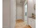 Bright hallway with white cabinets and an open doorway to the kitchen at 15803 W Almeria Rd, Goodyear, AZ 85395