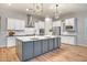 Bright kitchen with white cabinets, a large island, stainless steel appliances, and modern lighting at 15803 W Almeria Rd, Goodyear, AZ 85395