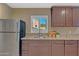 Well-equipped kitchenette features granite countertops, stainless steel fridge, and a view to the exterior at 15803 W Almeria Rd, Goodyear, AZ 85395