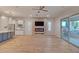 Bright, open living room featuring a stone fireplace and seamless access to the outdoor patio at 15803 W Almeria Rd, Goodyear, AZ 85395