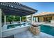 Resort-style pool with a spa, fire feature, travertine tile, and covered patio, perfect for entertaining at 15803 W Almeria Rd, Goodyear, AZ 85395