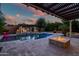 Inviting outdoor pool with hot tub, fire pit, and covered pergola, perfect for relaxing evenings at 15803 W Almeria Rd, Goodyear, AZ 85395