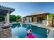 Beautiful pool with a pergola, fire feature, and lush landscaping, creating a perfect backyard retreat at 15803 W Almeria Rd, Goodyear, AZ 85395