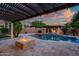 Lush backyard featuring a pool with a spa, fire pit, and covered pergola for relaxation at 15803 W Almeria Rd, Goodyear, AZ 85395