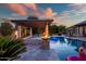Inviting pool with fire features and relaxing pergola, with night lighting perfect for outdoor enjoyment at 15803 W Almeria Rd, Goodyear, AZ 85395