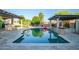 Beautiful outdoor pool surrounded by travertine tile, fire pit, and a serene pergola covered spa at 15803 W Almeria Rd, Goodyear, AZ 85395